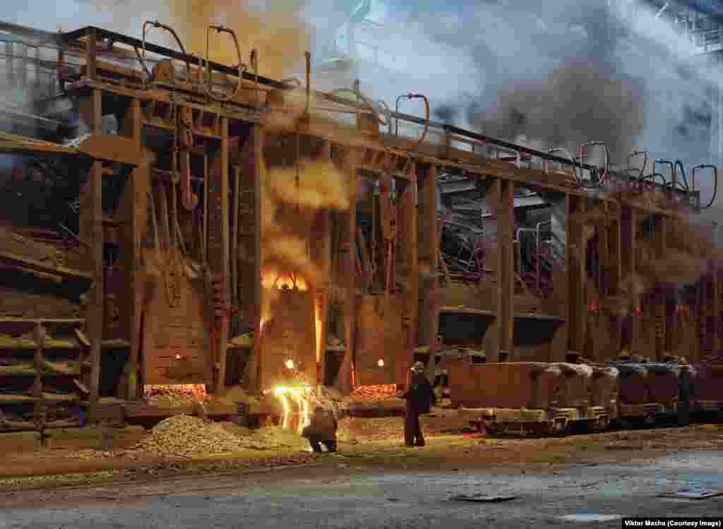 Workers taking a metal sample inside the foundry in Kryvyi Rih, Ukraine. While photographing one foundry in eastern Ukraine, Macha was told he had arrived a couple of weeks after a worker was crushed to death.