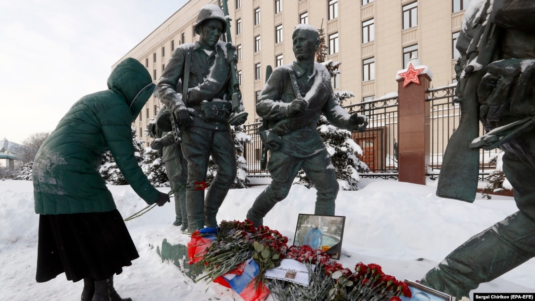 A woman places a red carnation near a picture of Russian pilot Roman Filipov, who was shot down in Syria, in front of the Russian Defense Ministry in Moscow on February 6. 