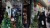 An Iranian chador clad woman passes by a Santa Claus shop in Tehran, December 22, 2014