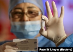 Медработник показывает флакон с вакциной QazCovid-in в центре вакцинации, расположенном в торгово-развлекательном центре в Алматы, Казахстан, 27 апреля 2021 года.