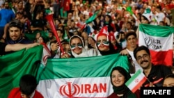 Thousand of men and women in Tehran's Azadi stadium watch Iran's national football team playing Portugal on June 25.