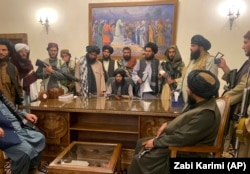 Taliban fighters take control of the presidential palace in Kabul after Afghan President Ashraf Ghani fled the country on August 15.