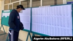 Мужчина ищет свою фамилию в списке избирателей. Бишкек. 11 апреля 2021 года.