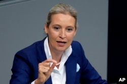 Alice Weidel conduce AfD, un partid profund anti-imigrație și anti-LGBT. Ea însăși este lesbiană, într-un parteneriat civil cu o femeie srilankeză cu care a adoptat doi copii, și are reședința în Elveția.