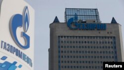 Russia -- A view shows a sign of a petrol station of Gazprom Neft company and the headquarters of the Russian natural gas producer Gazprom in Moscow, February 24, 2015