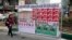 An Iranian woman walks past electoral posters on a street in Tehran.