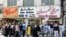 Iranians, wearing protective masks without observing social distancing, queue outside a money exchange office in the capital Tehran on May 9, 2020