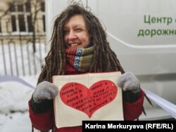 Одна из участниц "цепи солидарности" держит в руках сердце с именами политзаключенных. Фото: Карина Меркурьева
