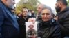 ARMENIA -- A woman holds a photograph of a serviceman who remains unaccounted for during a rally in Yerevan, November 24, 2020