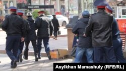 Полицейские уводят активистов с места их акции протеста в поддержку Макса Бокаева и Талгата Аяна. Алматы, 23 октября 2016 года.