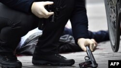 Експерт піднімає пістолет на місці вбивства колишнього депутата Держдуми Росії Дениса Вороненкова. Київ, 23 березня 2017 року