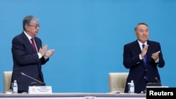 Казакстандын президенти Касым-Жомарт Токаев (солдо) жана өлкөнүн мурдагы президенти Нурсултан Назарбаев “Нур Отан” партиясынын 2019-жылы өткөн курултайында.
