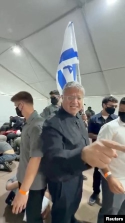 Itamar Ben Gvir a defilat cu drapelul israelian printre activiștii obligați să stea cu fața la podea, cerând soldaților care îi păzeau să nu ia seama la strigătele lor.