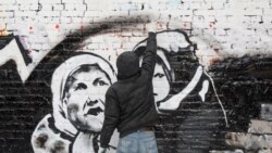 Russian street artist P183 paints a mural dedicated to forthcoming elections on a wall in central Moscow in February 2012.