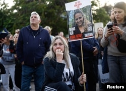 People in Tel Aviv watch broadcasts of the expected release of three female hostages on January 19.