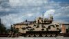 U.S. servicemen walk past a Bradley infantry fighting vehicle as they arrive for the joint U.S.-Georgian exercise Noble Partner 2016 in Vaziani.