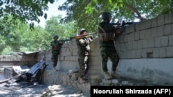 Members of the Afghan security forces take their positions during an ongoing clash between Taliban and Afghan forces in Mihtarlam, the capital of Laghman Province, on May 24.