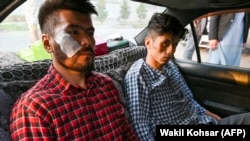 Afghan newspaper Etilaat-e Roz journalists Neamat Naqdi and Taqi Daryabi arrive at their office after being released from Taliban custody in Kabul on September 8.