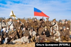 Reenactors from opposing sides of the battle pose for a photo after the mock fighting ended.