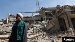 Әуе шабуылынан қираған полиция кеңсесі ғимаратының орнында тұрған адам. Иран, Тегеран, 4 наурыз, 2026 жыл.