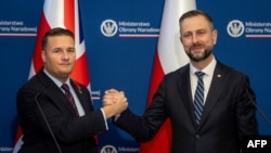 პოლონეთის ვიცეპრემიერი და თავდაცვის მინისტრი ვლადისლავ კოსინიაკ-კამიში და გაერთიანებული სამეფოს თავდაცვის მინისტრი უეს სტრიტინგი თავდაცვითი შეთანხმების ხელმოწერის შემდეგ. 2026 წლის 27 ოქტომბერი. ვარშავა.