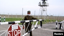 Пограничник закрывает шлагбаум на казахстанско-китайской границе, на контрольно-пропускном пункте «Хоргос». 