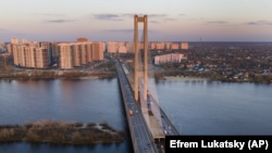 UKRAINE -- A view of the city bridge across the Dnipro River and the Left Bank, at sunset in Kyiv, March 23. 2020