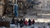 Syria -- Syrians walk over rubble of damaged buildings, while carrying their belongings, as they flee clashes between government forces and rebels in Tariq al-Bab and al-Sakhour neighborhoods of eastern Aleppo towards other rebel held besieged areas of Al