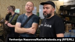 Сергій Волков з побратимами обговорює поточні задачі підрозділу по підготовці бортів до місій