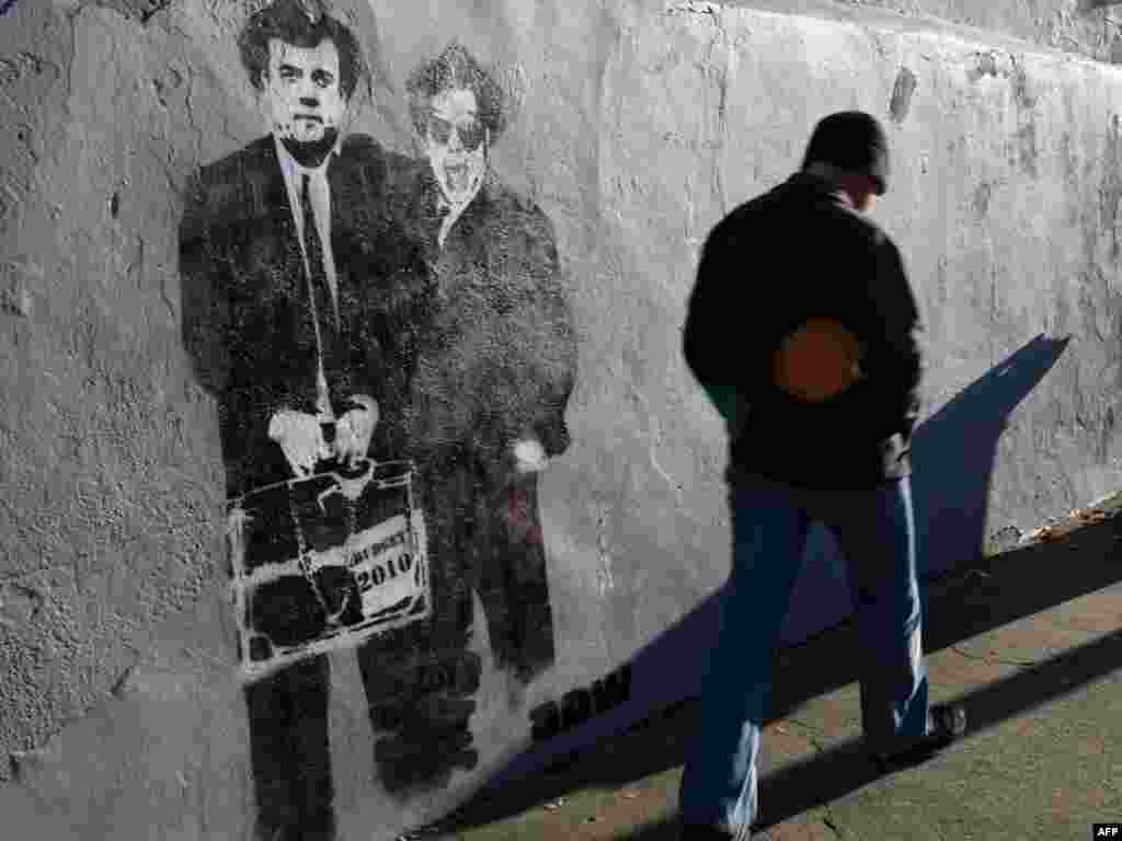 A mural depicting Irish Prime Minister Brian Cowen (right) and Finance Minister Brian Lenihan is pictured on a wall in Dublin, Ireland, on November 24. The Irish government presented a four-year austerity plan outlining 15 billion euros in savings, a key step toward securing an international bailout. Photo by Peter Muhly for AFP