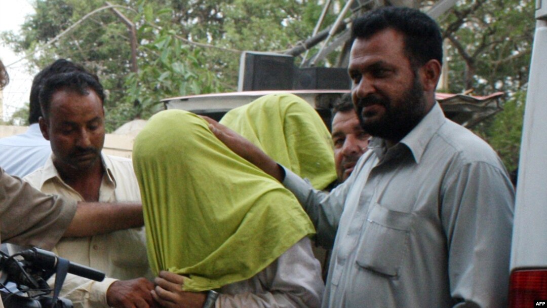Pakistani policemen escort suspected Taliban militants to a press conference in Karachi in May.