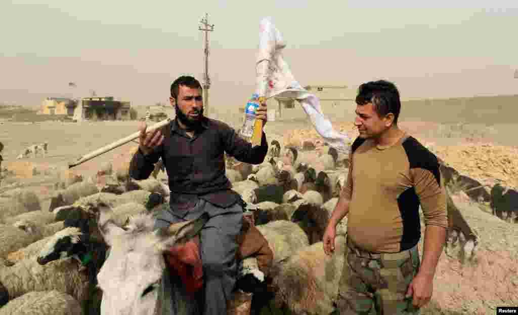 A man who just fled the village of Bazwaia carries a white flag as he talks to a member of the Iraqi special forces east of Mosul. (Reuters/Zohra Bensemra)