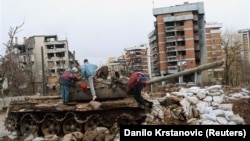 Деца си играат околу уништен тенк, Сараево, февруари, 1996 година