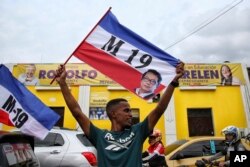 هواداران پترو در جشن پیروزی او پرچم‌های ام-۱۹ را منقش به تصویری از او در دست دارند