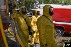 Ukrainian emergency workers wearing radiation protection suits attend training in at the Zaporizhzhya nuclear plant, which largely relies on water from the now-emptying reservoir at the Nova Kakhovka dam.