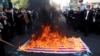 People watch as a U.S. flag is set on fire during the 42nd anniversary of the takeover of the U.S. Embassy in Tehran on November 4.