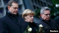 Berliniň häkimi Michael Mueller, Germaniýanyň kansleri Angela Merkel we nemes içeri işler ministri Thomas de Maiziere Roždestwo bazarynda ölenleriň hatyrasyna hormat bildirýärler. 20-nji dekabr, 2016 ý.
