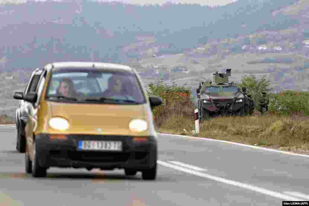 Vozila koja se kreću putem, u blizini oklopnog vozila Vojske Srbije, u Rudnici. (27. septembar) &nbsp;