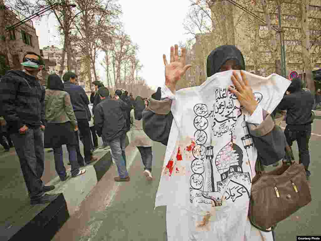 Iran -- An Iranian woman mask her face with a Ashura slogan (blood smear) during anti-government demonstration in Tehran, 27Dec2009 - Photo by Dara (Use only with Photographer's name