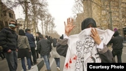 An Iranian woman masks her face with an Ashura slogan during an antigovernment demonstration in Tehran on December 27.