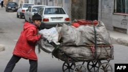 An Iranian boy pushes a cart filled with recyclable materials in south of Tehran on March 12, 2008. Iranian political factions made a final effort today to win votes on the last full day of a brief and muted campaign for an election expected to consolidat