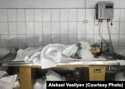 Vasily, an actor, vapes between takes while playing a corpse in a morgue.
