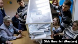 Ukraine -- Members of a local electoral commission empty a ballot box at a polling station after voting day in Kiev, October 26, 2014. 