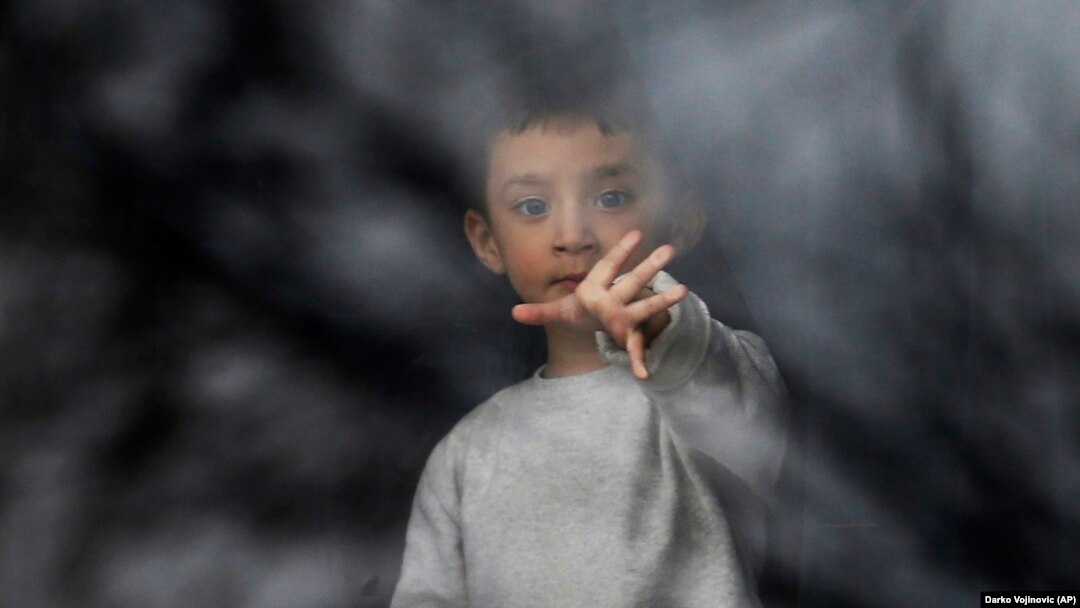 A migrant boy looks out a window in the Krnjaca refugee center near Belgrade on January 17.