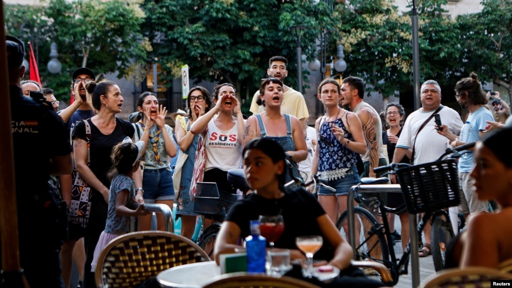 Protestuesit rrethuan turistët në një kafene në Palma de Mallorca, Spanjë.