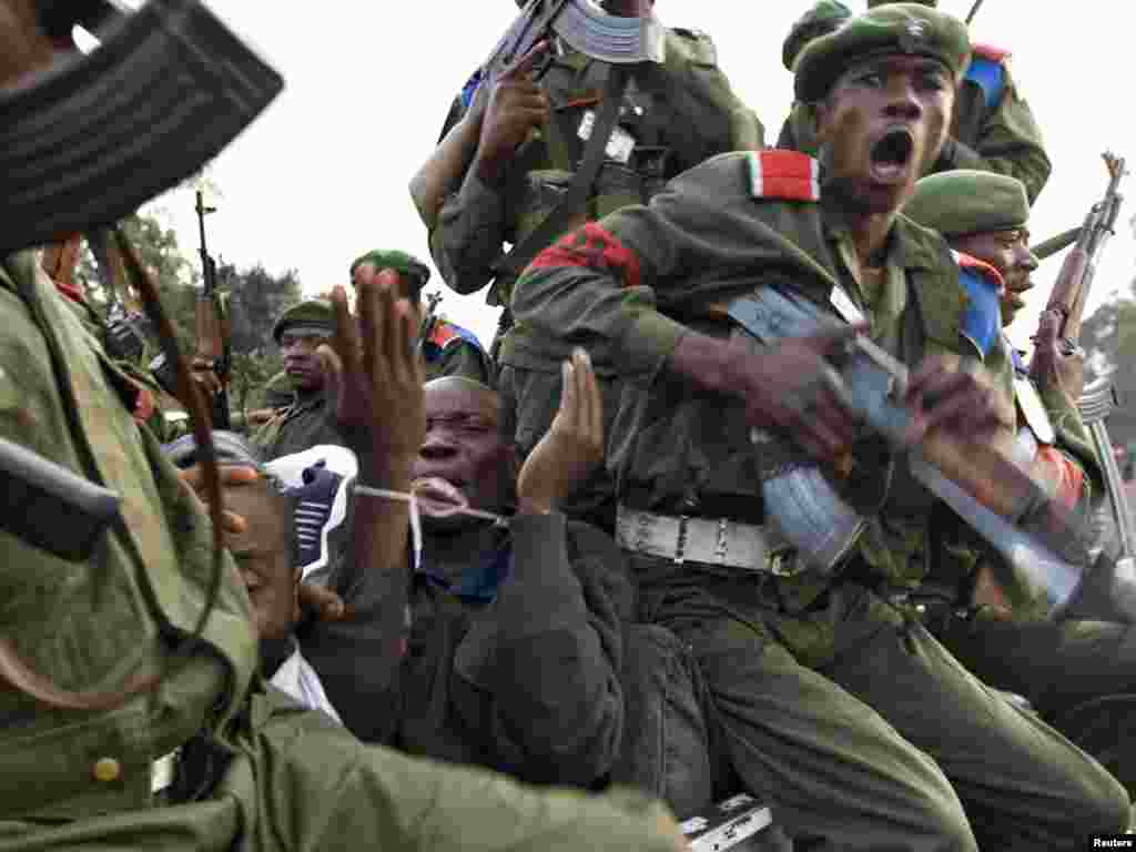 A prisoner with bound wrists pleads while being beaten by government soldiers just outside Goma in eastern Congo, November 23, 2008. Government troops hauled 26 men off a United Nations transport convoy near the front line on Sunday, accusing them of being a mixture of rebels and traditional Mai-Mai fighters, both of whom the Congolese army have fought running battles against during the past month. The army produced weapons they said belonged to the captives and accused the U.N. of collaborating with the rebels. REUTERS/Finbarr O'Reilly 