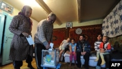 An elderly couple casts their ballots in the village of Rusaki in Ukraine's national elections for a new parliament on October 28.