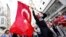 A masked demonstrator waves a Turkish flag during a protest in central Istanbul in late May.