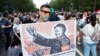 A demonstrator holds a placard depicting Hungarian Prime Minister Viktor Orban as Mao Tse-tung during a protest against the planned Chinese Fudan University campus in Budapest in June 2021.