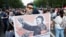 A demonstrator holds a sign depicting Hungarian Prime Minister Viktor Orban as Mao Tse-tung during a protest against the planned Chinese Fudan University campus in Budapest on June 5.